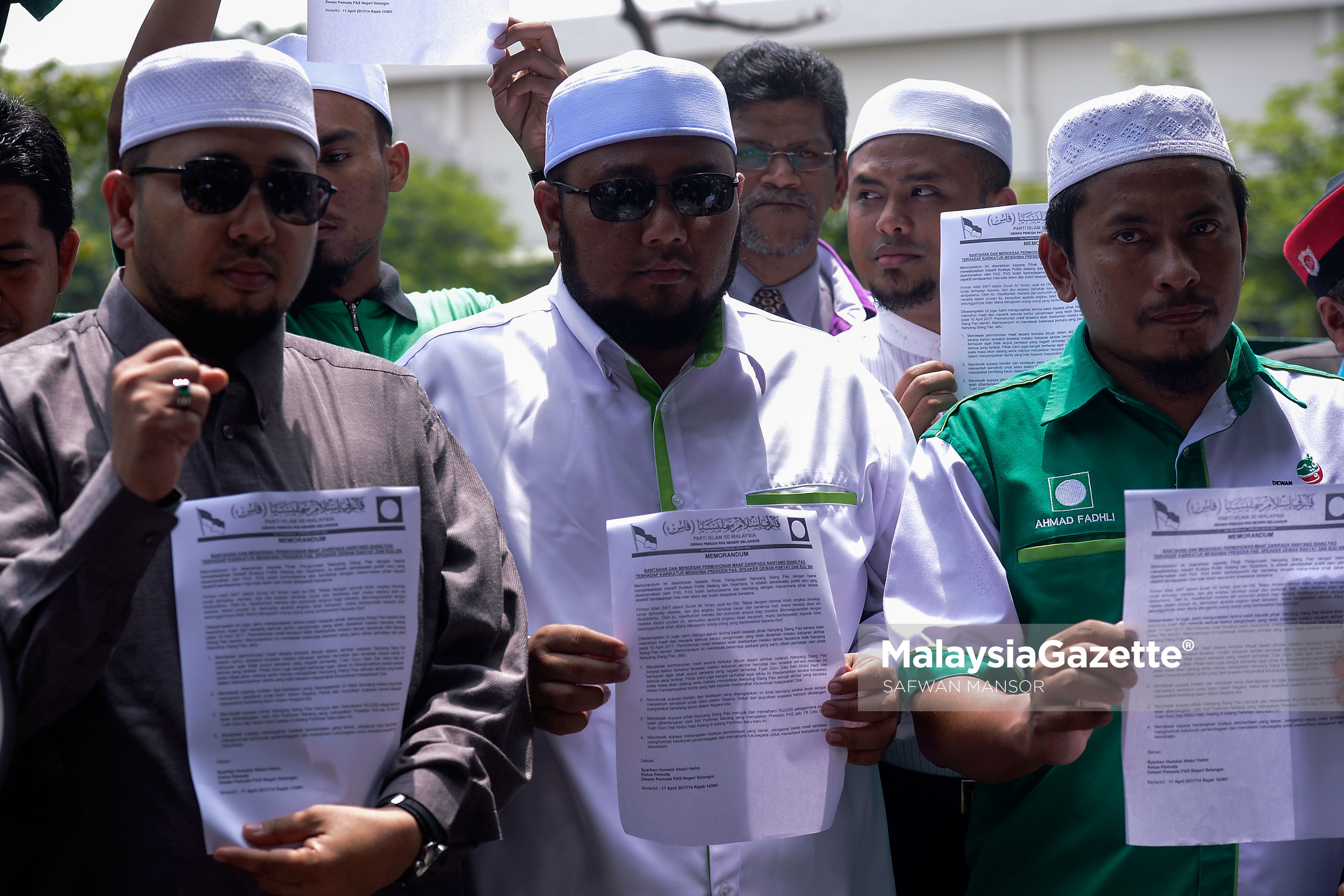 Ketua Pemuda PAS Selangor, Syarhan Humaizi Abdul Halim (tengah) dan Ketua Penerangan Pemuda PAS, Ahmad Fadhli Shaari (kanan) bersama sebahagian ahli dan penyokong PAS menunjukan memorandum bantahan yang diserahkan kepada pengurusan akhbar Nanyang Siang Pau pada Demontrasi & Serahan Memorandum Bantahan Kebiadapan Akhbar Nanyang Siang Pau dihadapan pejabat urusan akhbar tersebut di Petaling Jaya. foto SAFWAN MANSOR, 11 APRIL 2017