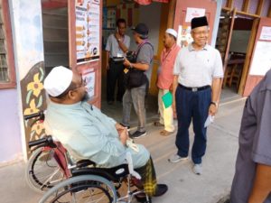 Mustapa bertanya khabar seorang pengundi Parlimen Jeli selepas beliau selesai membuang undi di pusat pengundian SK Batu Gajah.