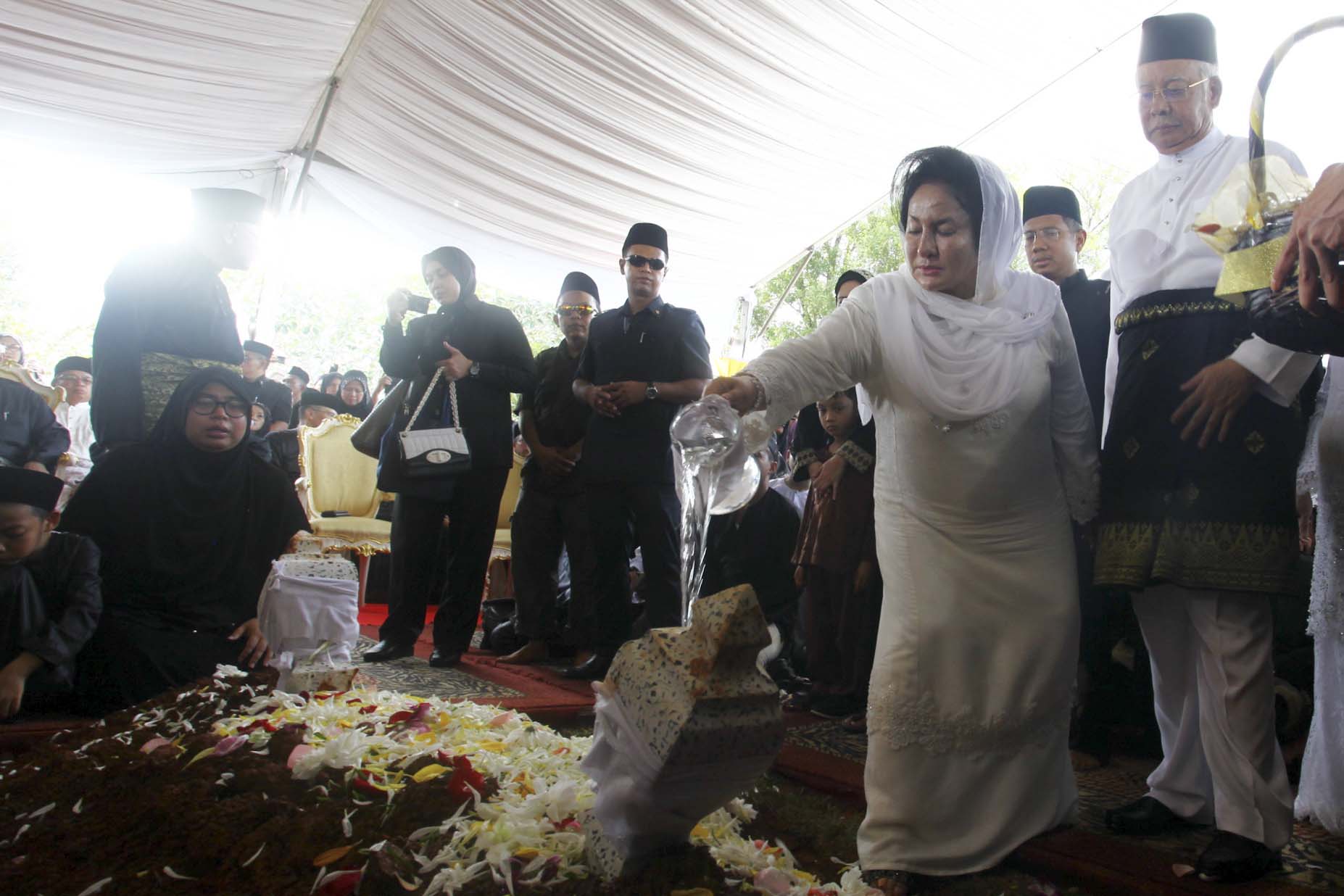 Isteri Perdana Menteri, Datin Seri Rosmah Mansor menyiram air mawar di pusara Allahyarham Tan Sri Adenan Satem sambil diperhatikan oleh Perdana Menteri, Datuk Seri Najib Tun Razak sebagai penghormatan terakhir selepas selamat disemadikan di Tanah Perkuburan Semariang, Sarawak. foto MALAYSIA GAZETTE, 12 JANUARI 2016.