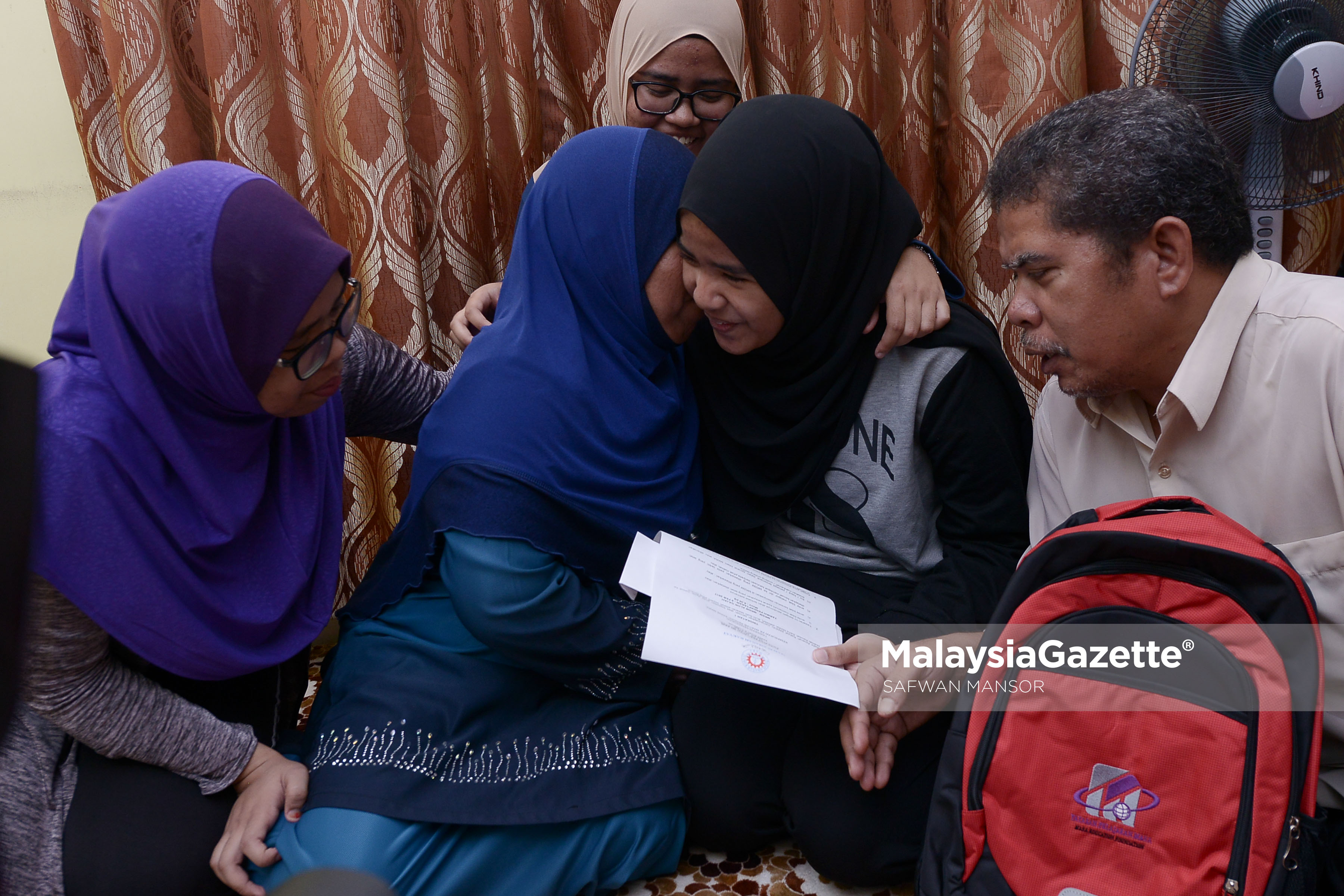 Pelajar, Aliyah Maisara Md Akir (dua kanan) dipeluk ibunya, Paizun Mat Jari (dua kiri) ketika berkongsi kegembiraan bersama bapanya, Md Akir Jaidin (kanan) serta dua kakaknya, Anis Rafidah Md Akir (tengah) dan Fatin Nur Syafiqah Md Akir (kiri) selepas menerima surat tawaran kemasukan tingkatan 1 MRSM 2017 daripada Menteri Pembangunan Kemajuan Luar Bandar dan Wilayah (KKLW), Datuk Seri Ismail Sabri Yaakob dirumah mereka di Blok 9 Flat Projek Perumahan Rakyat (PPR) Jelatek, Kuala Lumpur. foto SAFWAN MANSOR, 13 JANUARI 2017