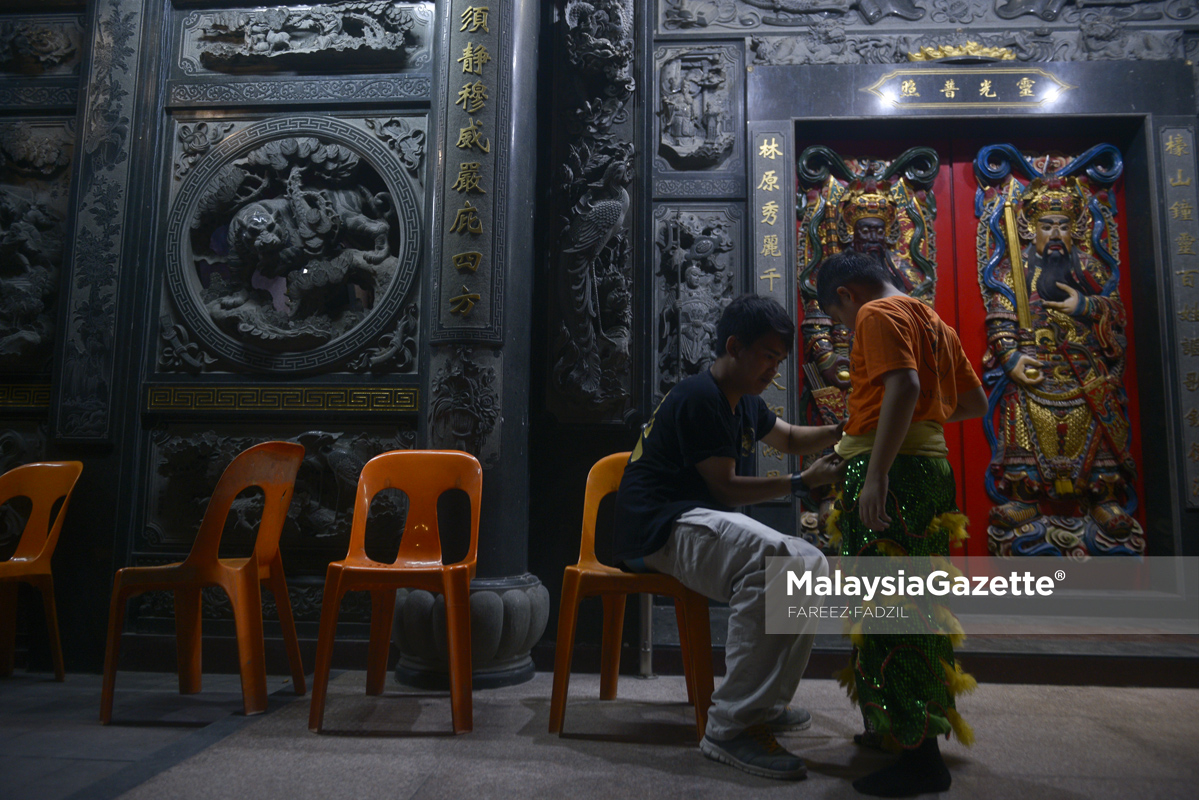 Jurulatih memperkemaskan pakaian anak buahnya sebelum memulakan sesi latihan tarian singa sempena sambutan perayaan Tahun Baru Cina yang akan datang ketika tinjauan lensa Malaysia Gazette di Tokong Kuah Nah, Setapak. foto FAREEZ FADZIL, 18 JANUARI 2017