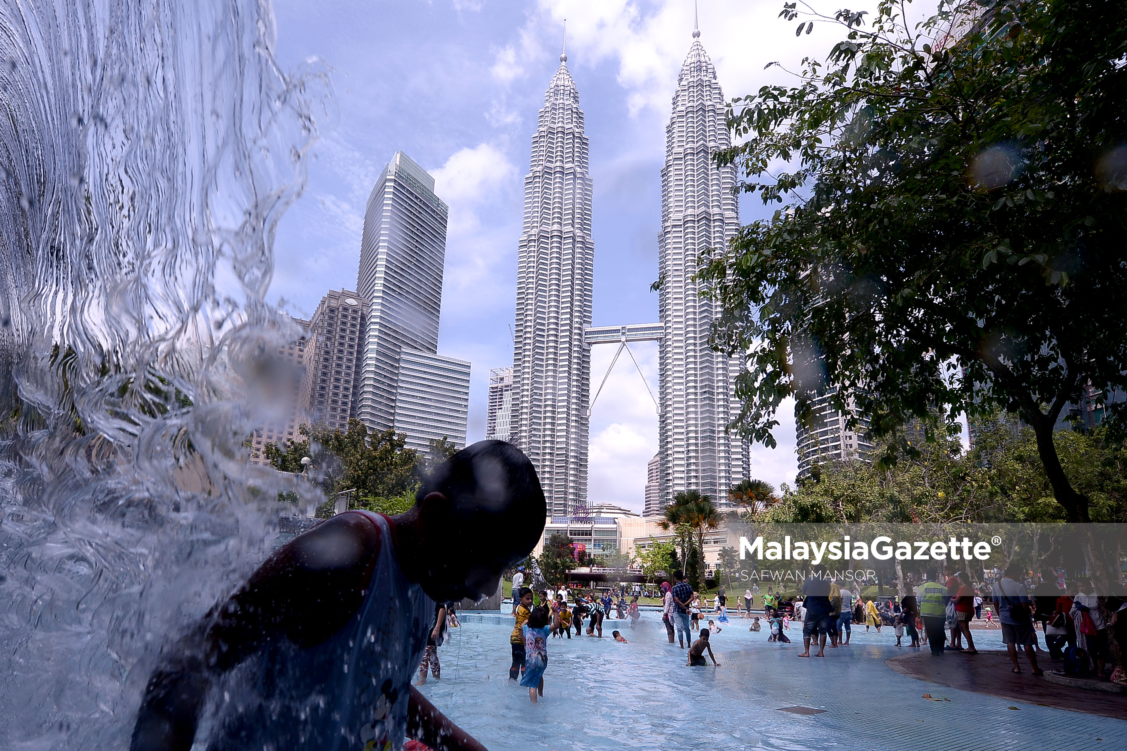 Berlatar belakang Menara Berkembar KLCC, gelagat seorang kanak-kanak mandi dibawah pancuran air ketika tinjauan lensa Malaysia Gazettte sempena cuti Tahun Baru Cina di Taman Rekreasi KLCC, Kuala Lumpur. foto SAFWAN MANSOR, 29 JANUARI 2017