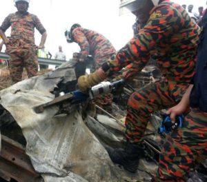 Anggota Bomba dan Penyelamat memotong bahagian depan treler untuk mengeluarkan mayat mangsa