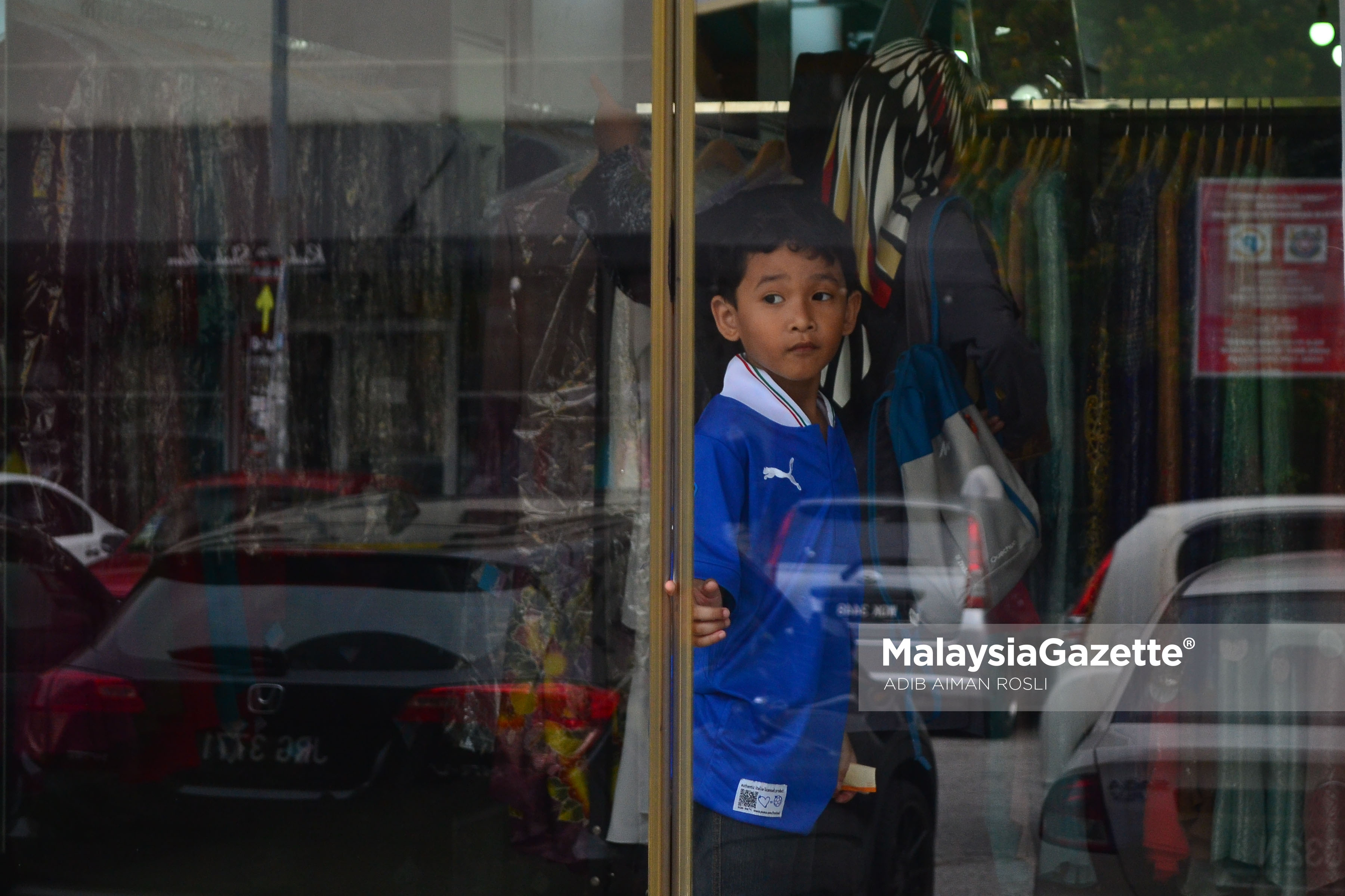 Seorang kanak- kanak leka bemain pintu kaca dengan jarinya ketika tinjauan lensa Malaysia Gazette di sebuah kedai butik, Seksyen 7, Shah Alam, Selangor. foto ADIB AIMAN ROSLI, 01 FEBRUARI 2017