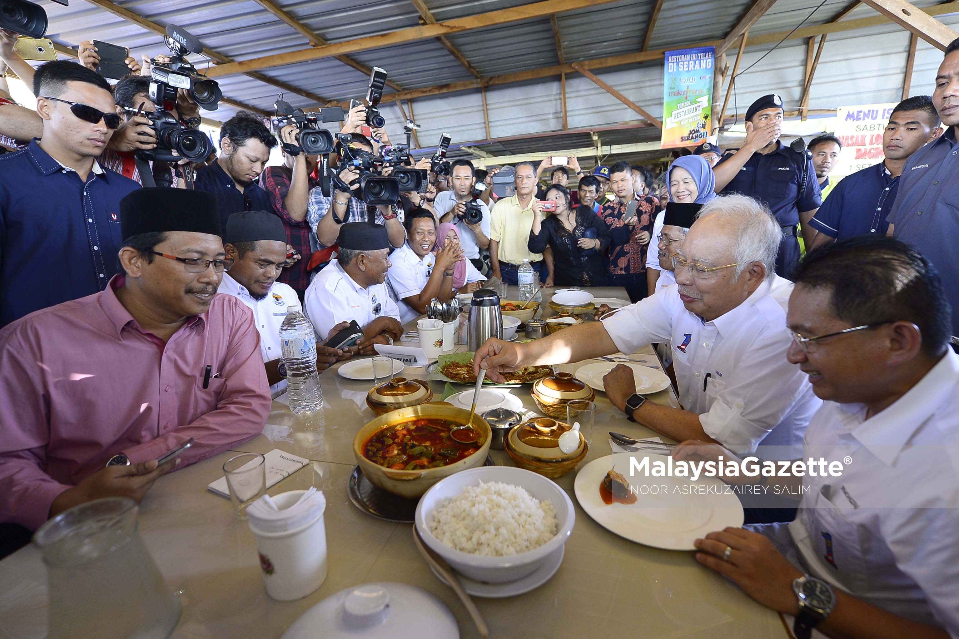 Perdana Menteri, Datuk Seri Najib Tun Abdul Razak diiringi Ahli Parlimen Kuala Selangor Datuk Seri Ir. Mohizam Ibrahim (kanan) mencuba masakan ikan sembilang asam pedas di warung Atok Asam Pedas ketika hadir pada Program Jom Bantu Rakyat Kuala Selangor di Jeti Nelayan Sungai Sembilang, Jeram, Selangor. foto NOOR ASREKUZAIREY SALIM, 03 FEBRUARI 2017