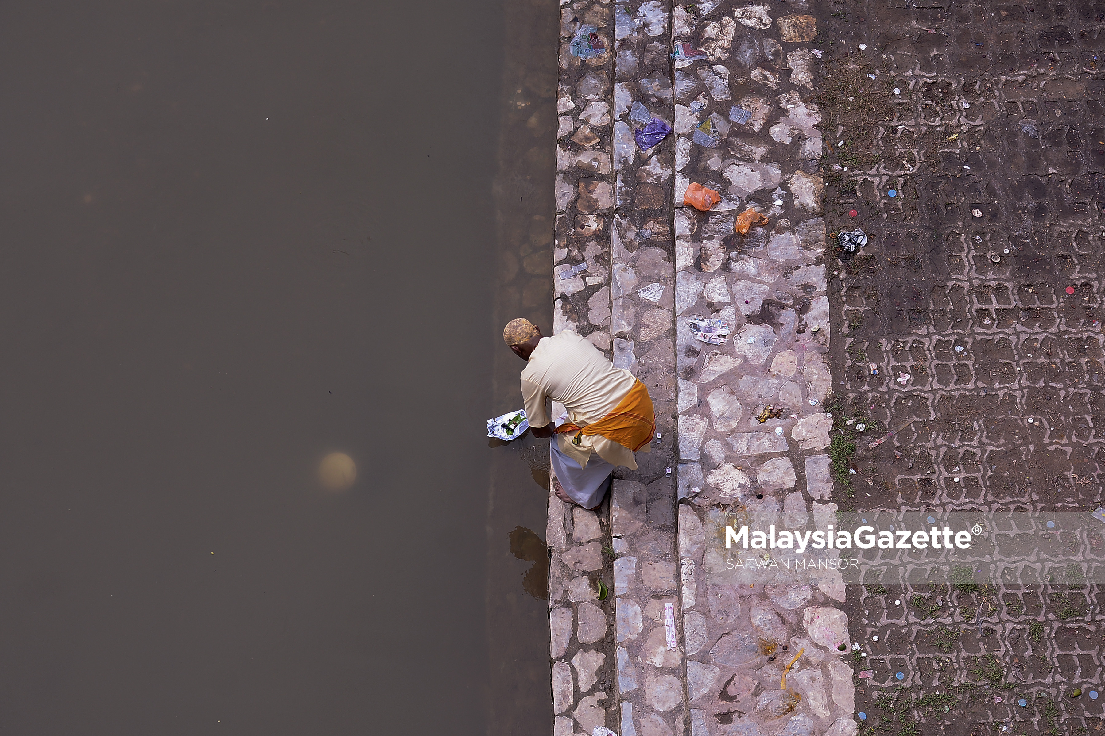 Seorang penganut agama Hindu melakukan salah satu ritual keagamaan mereka di tebing Sungai Gombak sempena sambutan Thaipusam ketika tinjauan lensa Malaysia Gazette di Btu Caves, Selangor. foto SAFWAN MANSOR, 08 FEBRUARI 2017