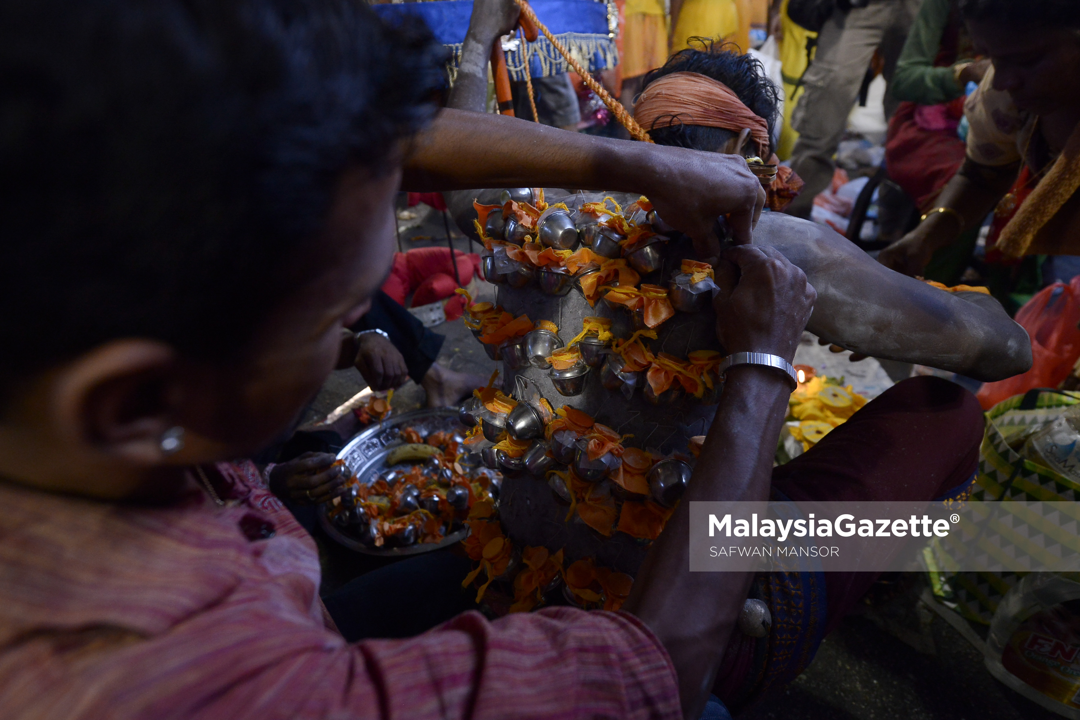 Seorang penganut agama Hindu membantu rakannya memakaikan Kavadi yang dicucuk pada badannya sebelum melakukan ritual keagamaan sempena sambutan hari perayaan Thaipusam di Batu Caves, Selangor. foto SAFWAN MANSOR, 09 FEBRUARI 2017