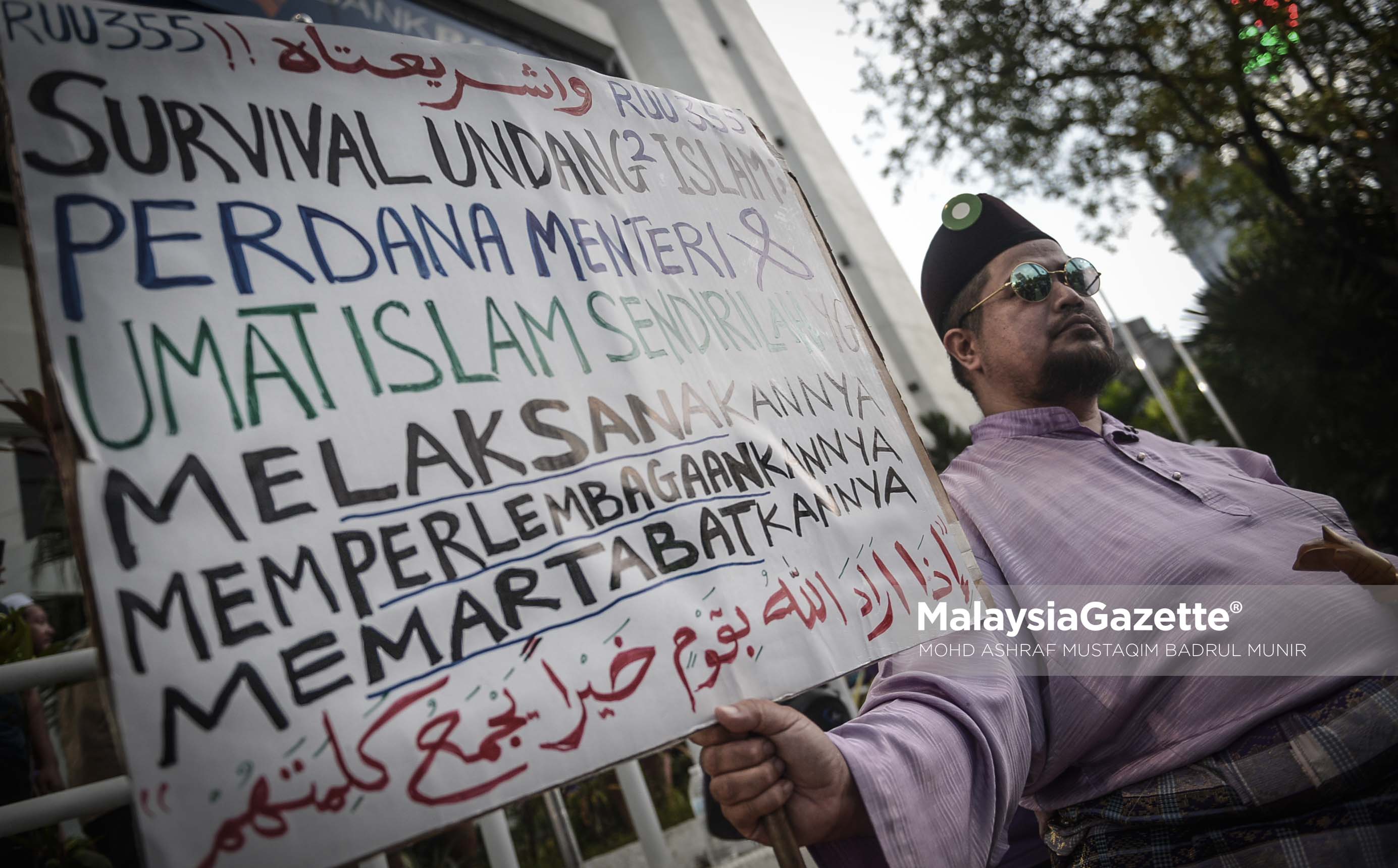 Seorang lelaki memegang sepanduk yang menyatakan sokongan pada Himpunan RUU 355 di Padang Merbok, Kuala Lumpur. foto ASHRAF MUSTAQIM BADRUL MUNIR, 18 FEBRUARI 2017.