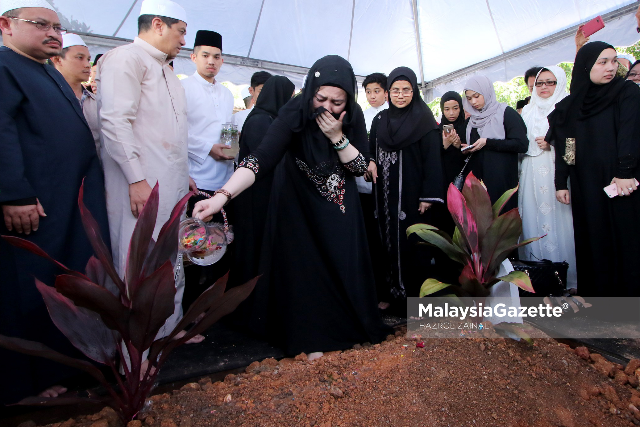 Kakak kepada Menteri Besar Selangor, Ummi Hafilda Ali (tengah) menyiram air mawar di pusara ibunya  Allahyarham Che Tom Yahaya  di Tanah Perkuburan Islam Kampung Klang Gate, Hulu Kelang, Selangor. foto MOHD HAZROL ZAINAL 18 FEBRUARI 2017