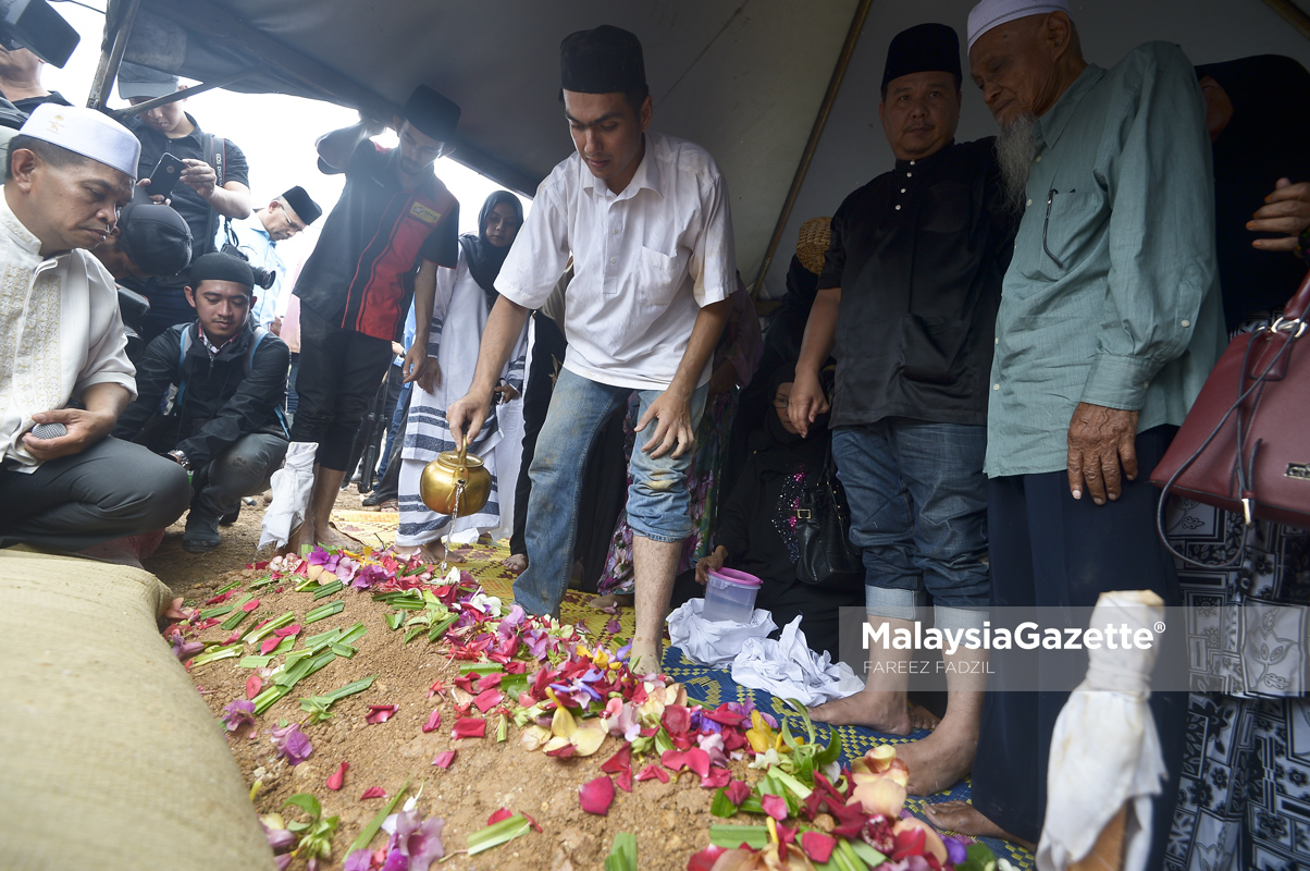 Anak, Putera Hang Nadim (tengah) menyiram air mawar dipusara bapanya, Allahyarham Tan Sri Jins Samsuddin selepas selamat dikebumikan di Masjid Al-Ridhuan, Hulu Kelang, Selangor. foto FAREEZ FADZIL, 02 MAC 2017