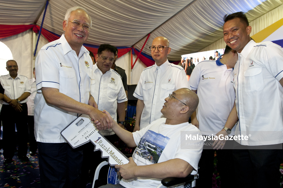 Perdana Menteri, Datuk Seri Najib Tun Razak menyerahkan kunci 1Razak Mansion kepada Orang Kelainan Upaya (OKU), Yong Chee Keong (duduk, tengah) diiringi Menteri Wilayah Persekutuan, Tengku Adnan Tengku Mansor (dua kiri) pada Majlis Penyerahan Kunci 1Razak Mansion di Sungai Besi, Kuala Lumpur. foto FAREEZ FADZIL, 15 MAC 2017