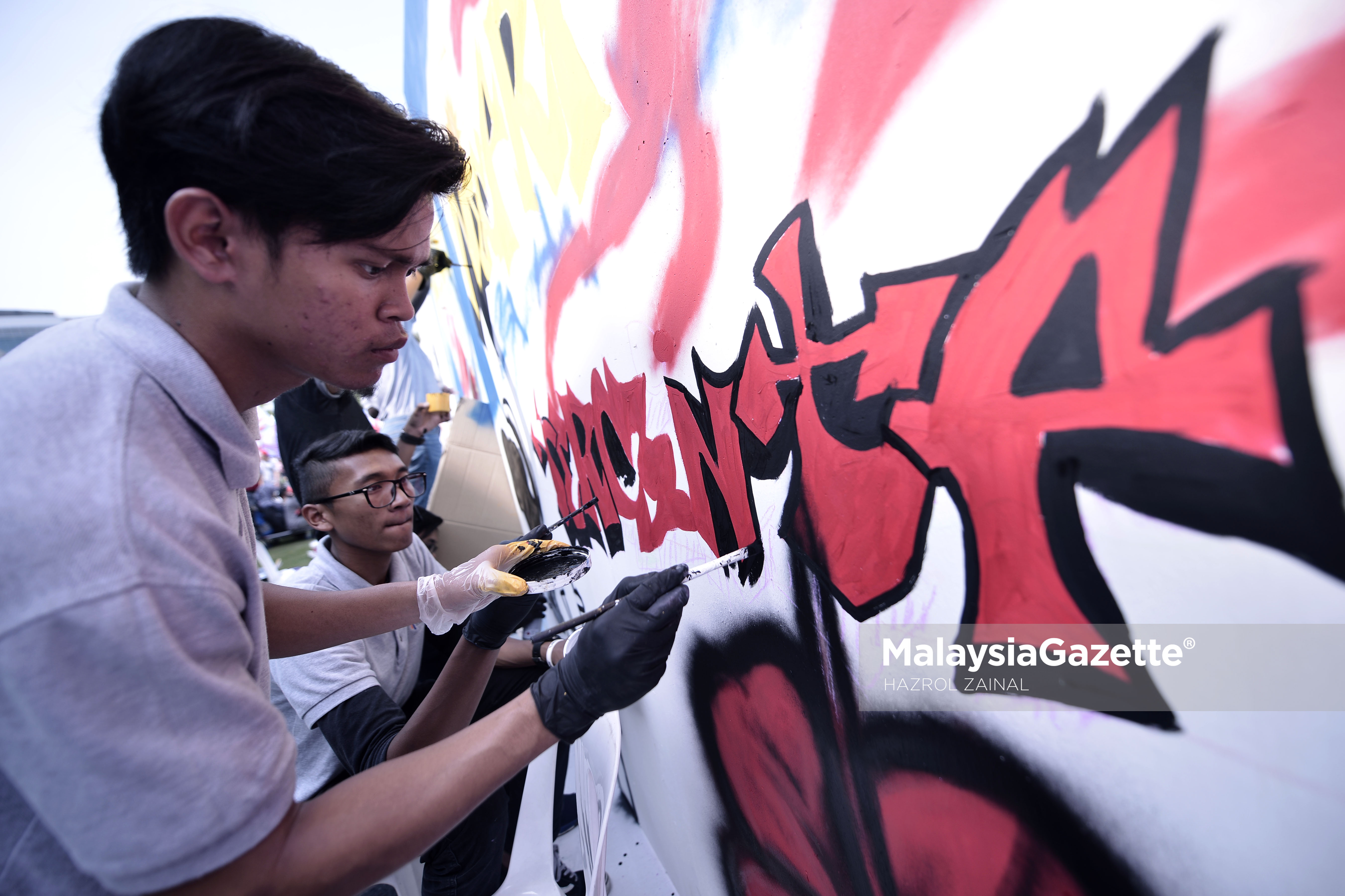 Pelukis Mural, Aiman Ramli mewarnakan lukisan muralnya semperna pameran kempen Ekspresi Negaraku di Putrajaya. foto MOHD HAZROL ZAINAL, 18 MAC 2017.