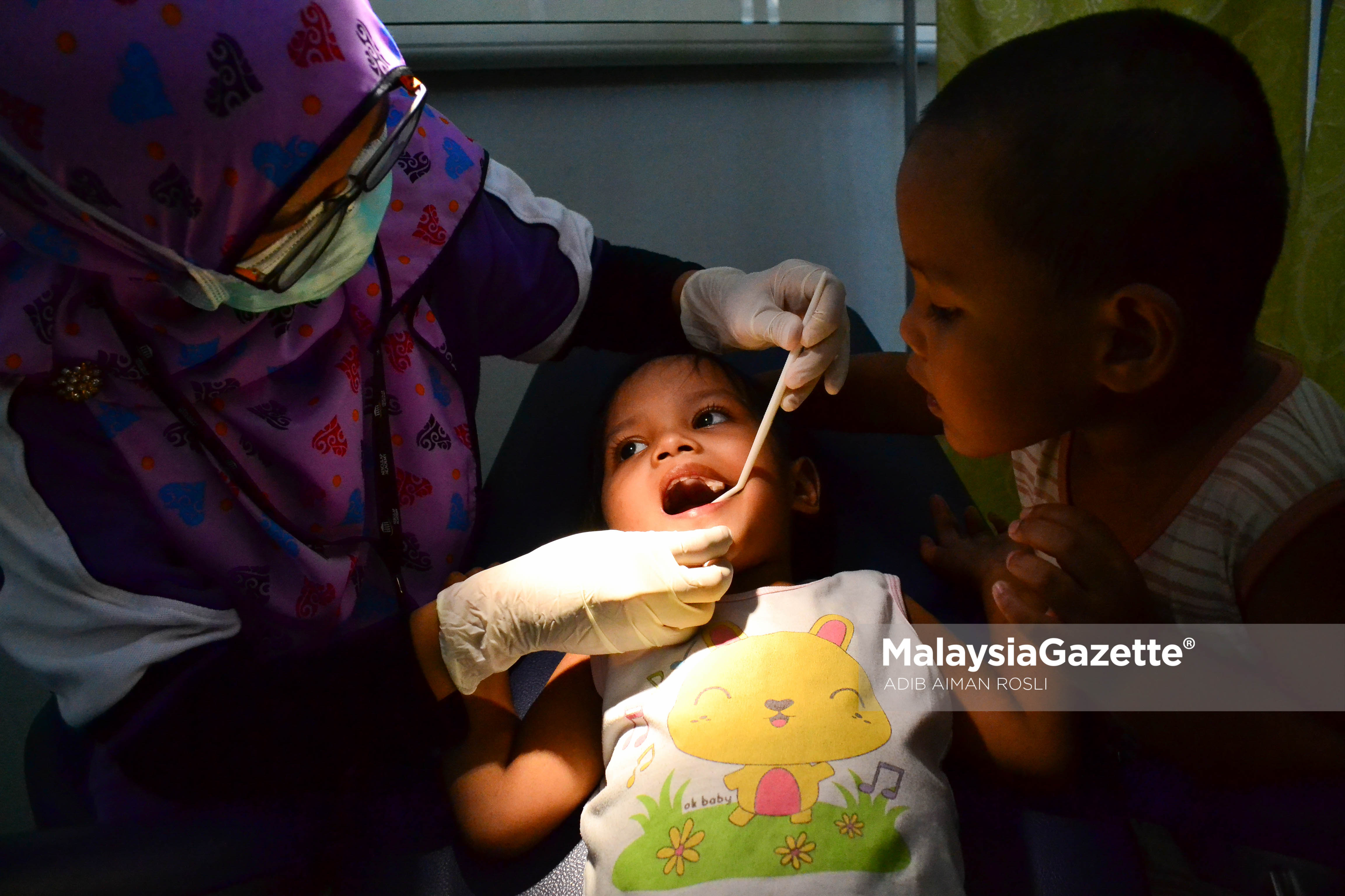Adik Nur Hafiya Qaireen (tengah) di temani abangnya Muhammad Hakim Qayyum membuat pemeriksaan gigi secara percuma pada Program Kembara Sihat 1 Malaysia "Ziarah Senyum" di Masjid Jamek Kampong Bharu, Kuala Lumpur. foto ADIB AIMAN ROSLI, 22 MAC 2017