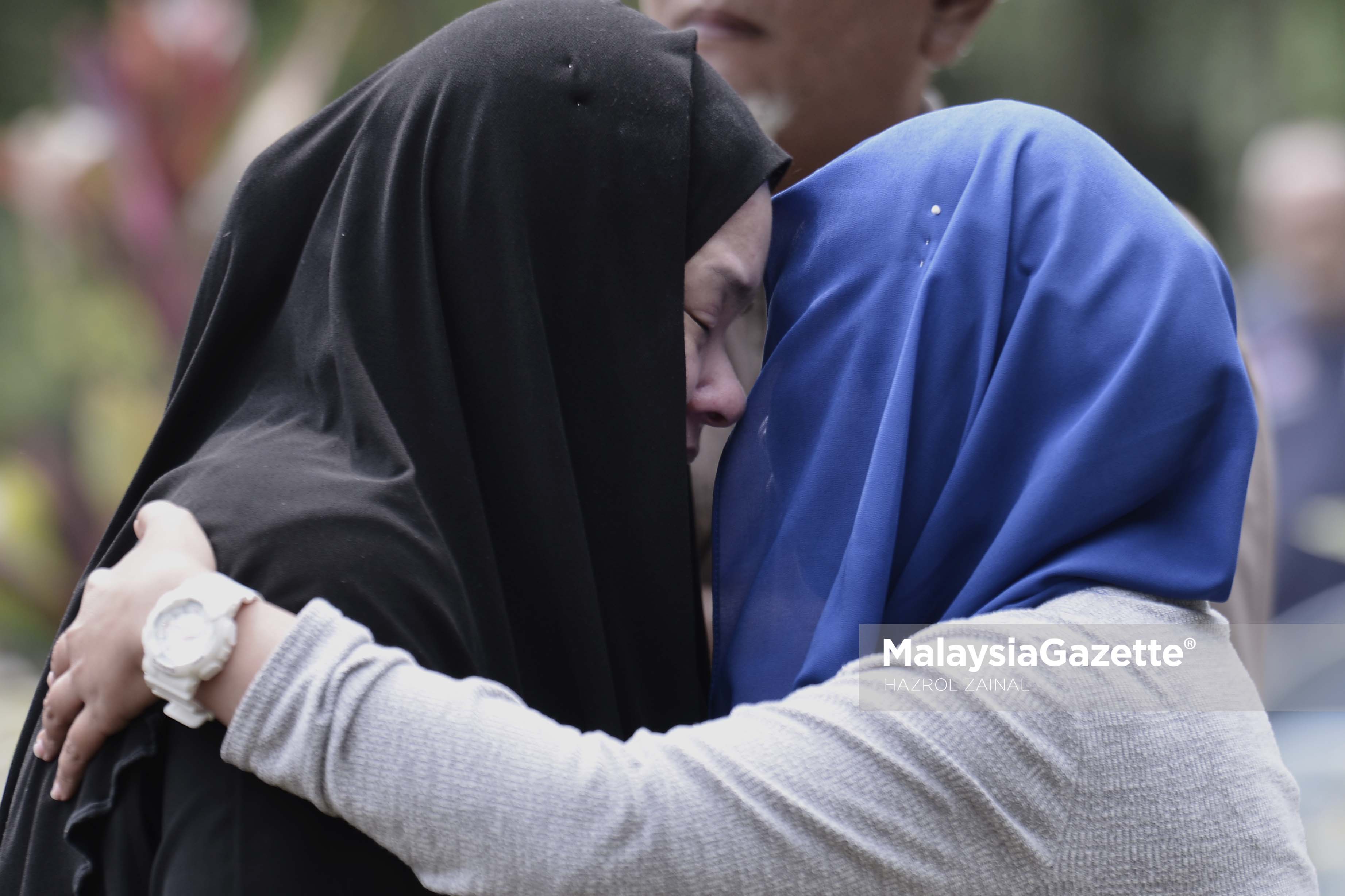 Isteri Allahyarham, Nora Ariffin, ditenangkan sanak saudara ketika pengebumian suaminya Allahyarham Johan Nawawi di Tanah Perkuburan Islam Bukit Kiara, Kuala Lumpur. foto MOHD HAZROL ZAINAL, 24 MAC 2017.
