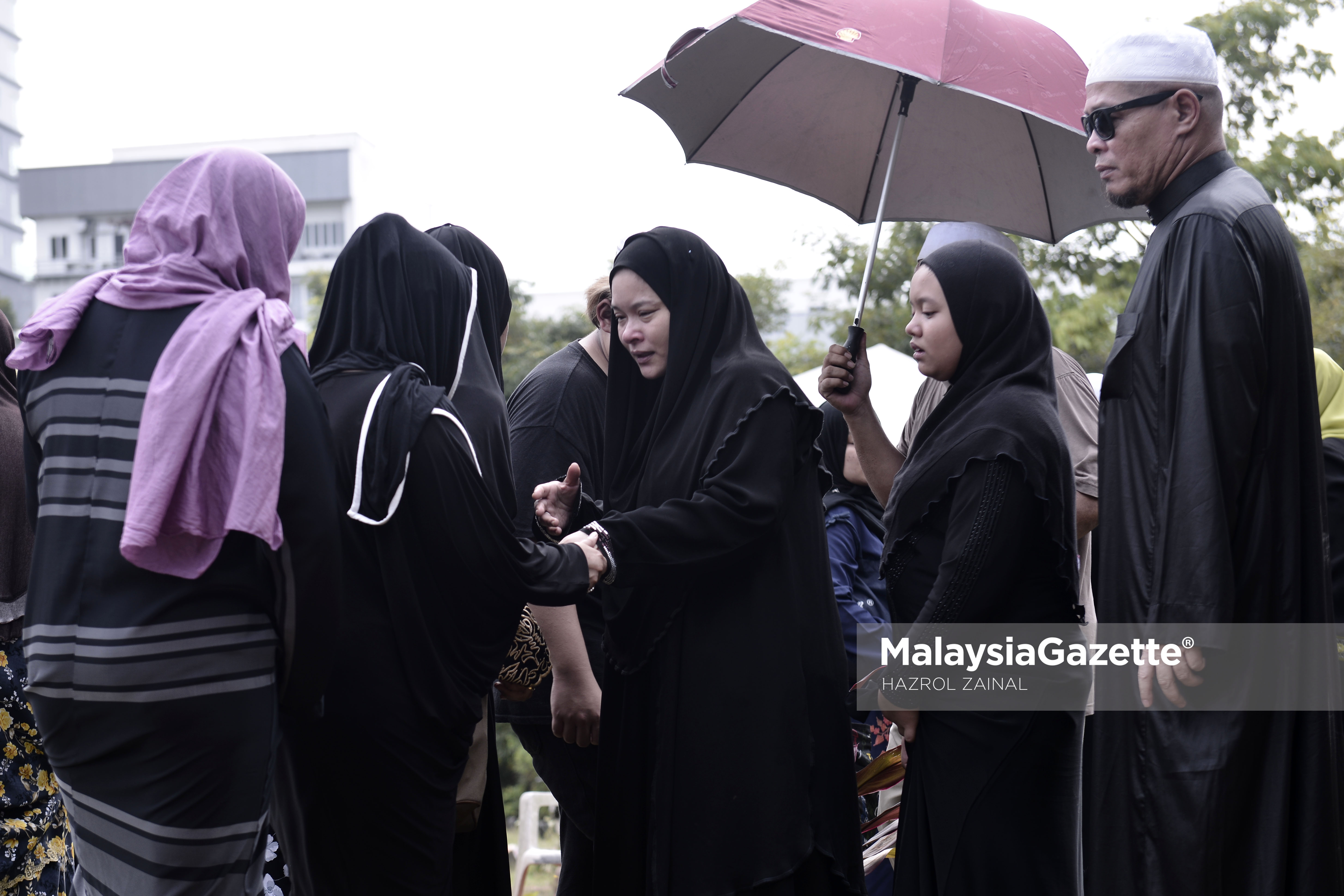 Isteri Allahyarham, Nora Ariffin (tengah) ditenangkan sanak saudara ketika pengebumian suaminya Allahyarham Johan Nawawi di Tanah Perkuburan Islam Bukit Kiara, Kuala Lumpur. foto MOHD HAZROL ZAINAL, 24 MAC 2017.