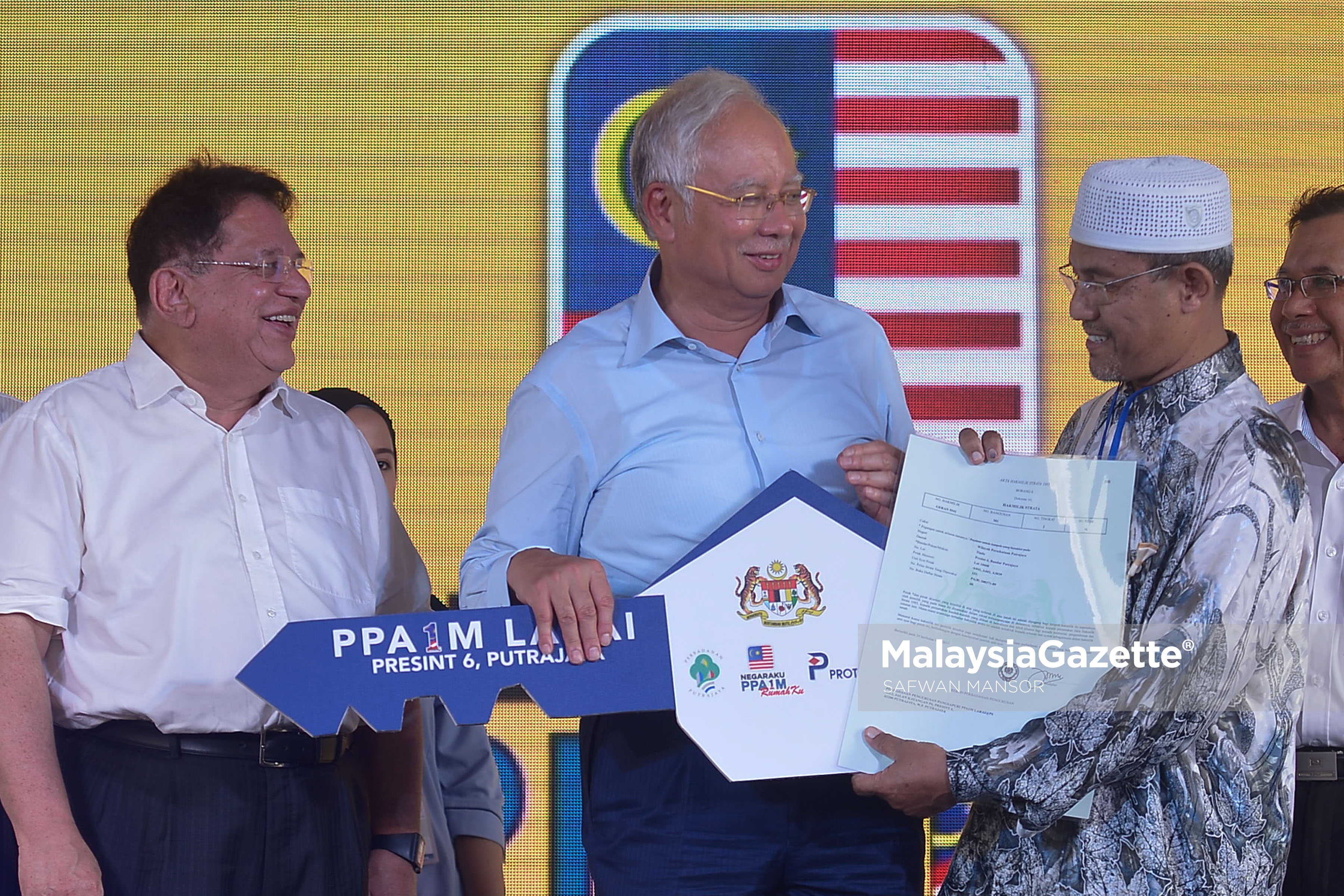 Perdana Menteri, Datuk Seri Najib Tun Razak diiringi Menteri Wilayah Persekutuan, Datuk Seri Tengku Adnan Tengku Mansor menyampaikan replika kunci rumah dan geran tanah kepada Penjawat Awam, Ismail Jalil pada Majlis Penyerahan Kunci Kepada Pemilik Perumahan Penjawat Awam 1Malaysia (PPA1M) Larai, Presint 6, Putrajaya. foto SAFWAN MANSOR, 27 MAC 2017