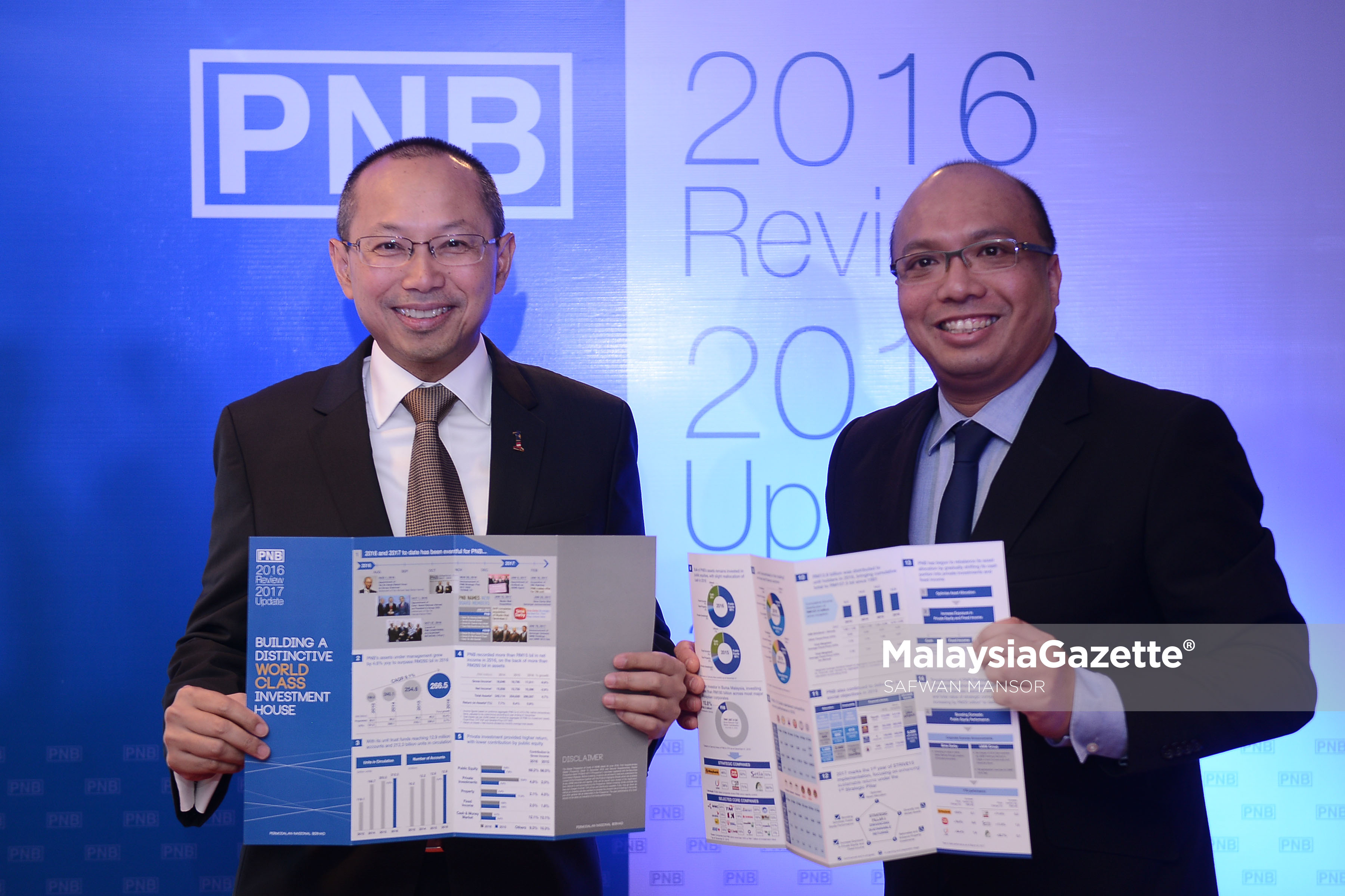 Pengerusi Permodalan Nasional Bhd (PNB), Tan Sri Abdul Wahid Omar (kiri) bersama Ketua Pegawai Eksekutif (CEO) kumpulan Permodalan Nasional Berhad (PNB), Datuk Abdul Rahman Ahmad (kanan) menunjukkan laporan Prestasi Tahunan PNB bagi Tahun 2016/2017 di Menara PNB, Kuala Lumpur. foto SAFWAN MANSOR, 27 MAC 2017
