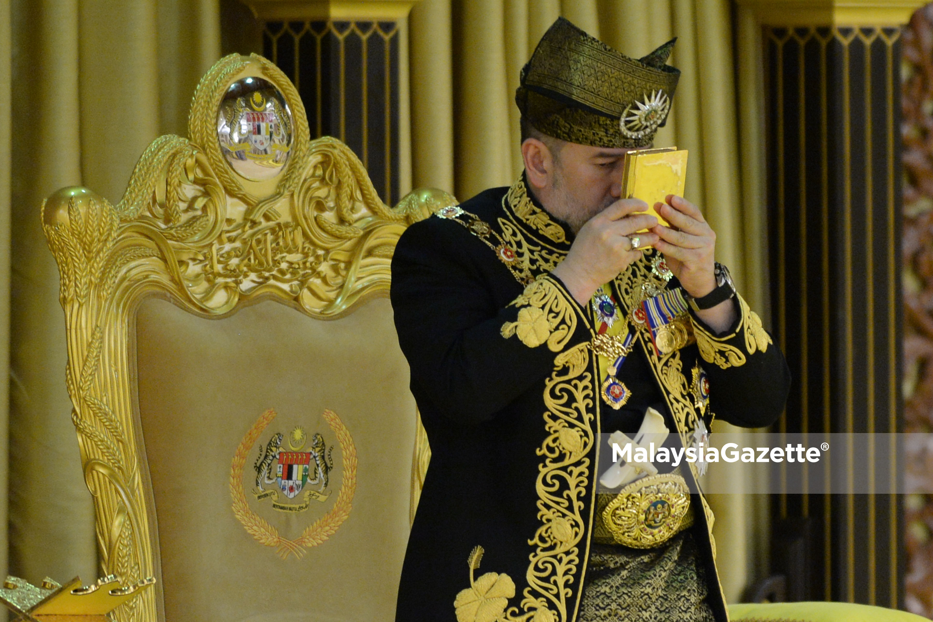 Yang di-Pertuan Agong Sultan Muhammad V berkenan mencium kitab suci Al-Quran pada Istiadat Pertabalan Yang di-Pertuan Agong Ke-XV di Istana Negara. foto ihsan JABATAN PENERANGAN MALAYSIA/Asraf Affandi Azlan