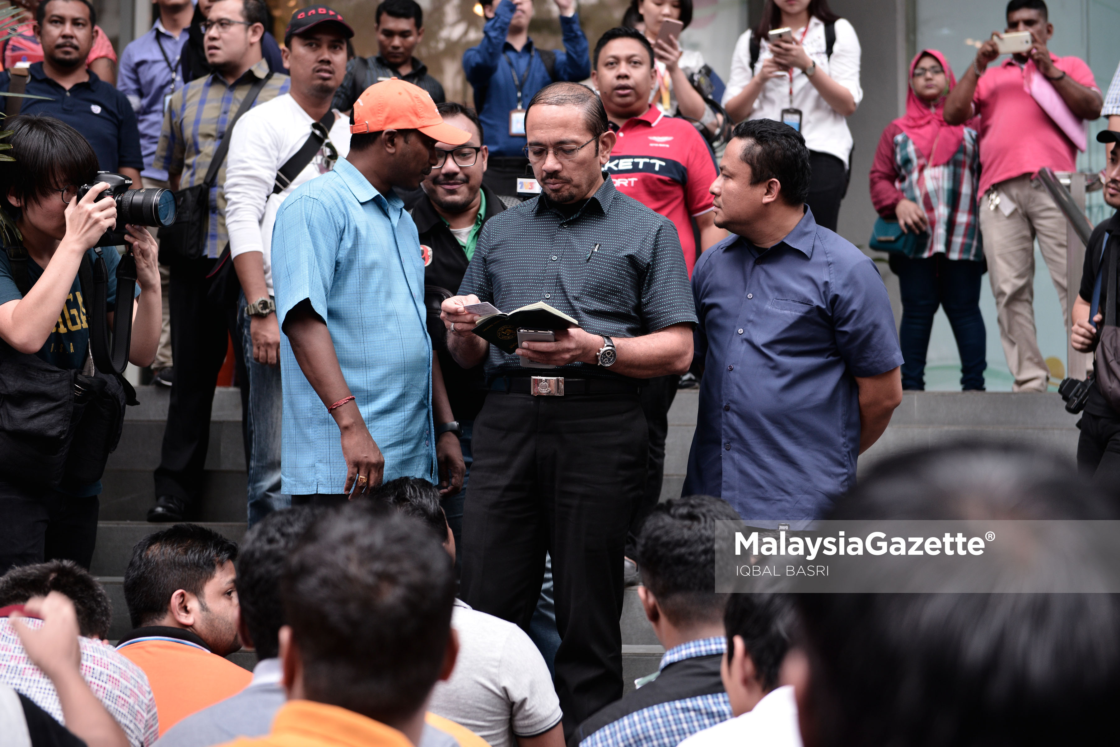 Ketua Pengarah Imigresen, Datuk Seri Mustafar Ali memeriksa pasport pekerja asing yang ditahan dalam Operasi Jabatan Imigresen di Plaza Low Yat, Kuala Lumpur. foto IQBAL BASRI, 17 MEI 2017.