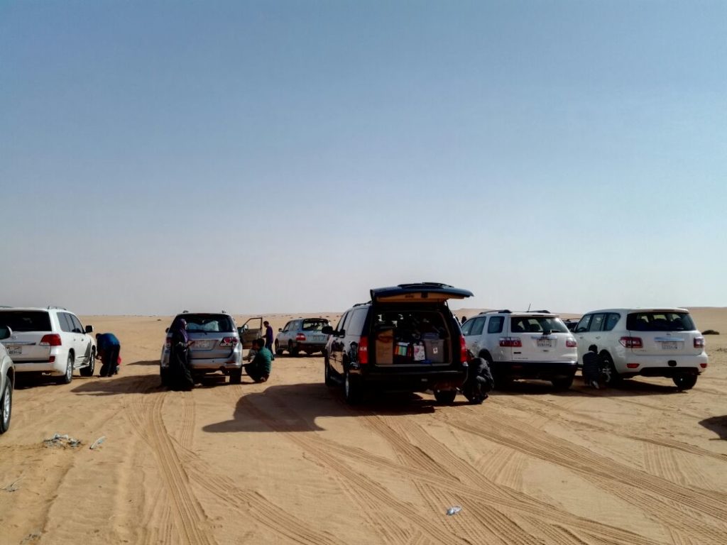 Ahli rombongan mengempiskan tayar kereta sebelum merentasi padang pasir.