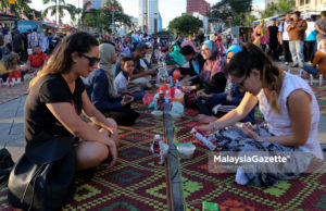 Dua pelancong dilihat turut mengambil peluang merasai berbuka puasa beramai-ramai ketika tinjauan Lensa Malaysia Gazette di perkarangan Banggunan Sultan Abdul Samad, Dataran Merdeka, Kuala Lumpur. foto SAFWAN MANSOR, 03 JUN 2017