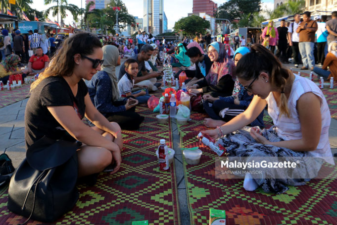 Dua pelancong dilihat turut mengambil peluang merasai berbuka puasa beramai-ramai ketika tinjauan Lensa Malaysia Gazette di perkarangan Banggunan Sultan Abdul Samad, Dataran Merdeka, Kuala Lumpur. foto SAFWAN MANSOR, 03 JUN 2017