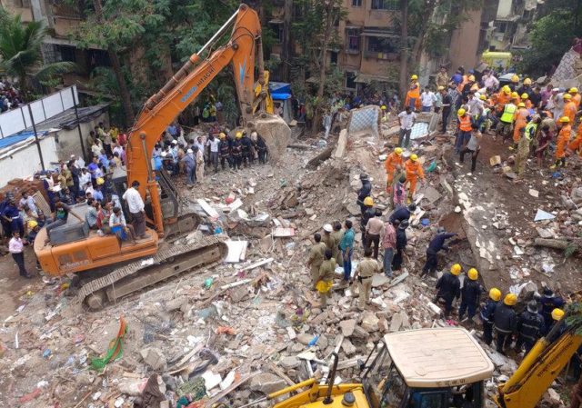 Firefighters and rescue workers search for survivors at the site of a collapsed building in the suburbs of Mumbai