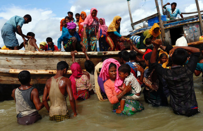 Rohingya refugees get off a boat after crossing the Bangladesh-Myanmar border through the Bay of Bengal, in Shah Porir Dwip