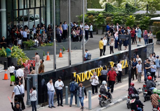 Office workers leave a building following an earthquake in Jakarta