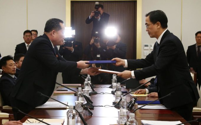 Head of the North Korean delegation, Ri Son Gwon exchanges documents with South Korean counterpart Cho Myoung-gyon after their meeting at the truce village of Panmunjom
