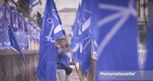Penduduk, Noraliza Ismail, 38, melakukan kerja-kerja pemasangan bendera Barisan Nasional (BN) sempena Pilihan Raya Umum ke-14 (PRU-14) di hadapan PPR Perkasa, Jalan Nakhoda Yusof, Kuala Lumpur