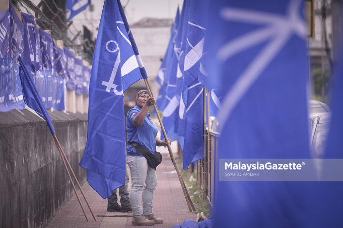 Penduduk, Noraliza Ismail, 38, melakukan kerja-kerja pemasangan bendera Barisan Nasional (BN) sempena Pilihan Raya Umum ke-14 (PRU-14) di hadapan PPR Perkasa, Jalan Nakhoda Yusof, Kuala Lumpur