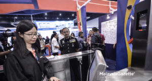 Ketua Pengarah Jabatan Imigresen, Datuk Seri Mustafar Ali melihat seorang petugas menggunakan prototaip sistem pengecaman wajah bagi menggantikan sistem biometric di pintu masuk utama negara pada Pameran Perkhidmatan Pertahanan Asia (DSA) Ke-16 di Pusat Pameran dan Dagangan Antarabangsa Malaysia (MITEC). foto SYAFIQ AMBAK, 19 APRIL 2018.