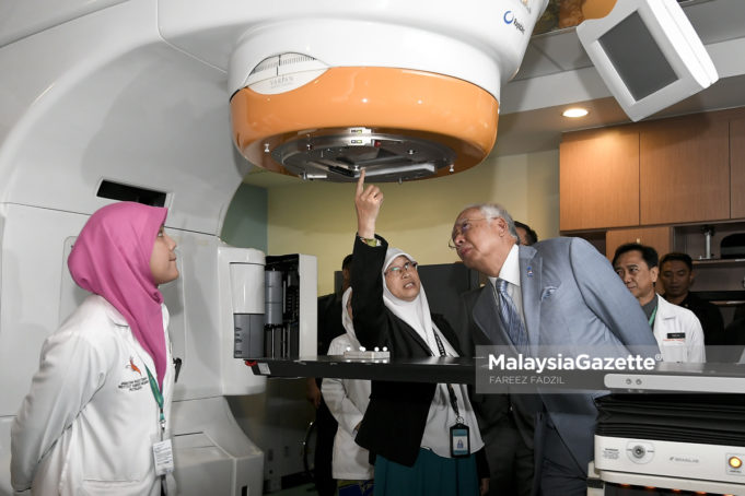 Perdana Menteri, Datuk Seri Najib Tun Razak (kanan) diberi penerangan dari Ketua Pegawai Sains Fizik IKN, Mahzom Pawanchek (dua kiri) mengenai rawatan Novalis TX semasa melawat Jabatan Radioterapi & Onkologi pada Perasmian Institut Kanser Negara (IKN) di IKN, Putrajaya. foto FAREEZ FADZIL, 24 APRIL 2018