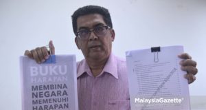 Bekas Setiausaha Parti Pribumi Bersatu Malaysia (PPBM), Kamarulazman Habibur Rahman menujukkan salinan manifesto DAP dan Pakatan Harapan kepada media di Wangsa Melawati, Kuala Lumpur. foto NOOR ASREKUZAIREY SALIM, 01 MEI 2018
