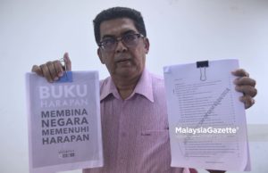 Bekas Setiausaha Parti Pribumi Bersatu Malaysia (PPBM), Kamarulazman Habibur Rahman menujukkan salinan manifesto DAP dan Pakatan Harapan kepada media di Wangsa Melawati, Kuala Lumpur. foto NOOR ASREKUZAIREY SALIM, 01 MEI 2018