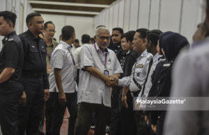 Pengerusi SPR, Tan Sri Mohd. Hashim Abdullah bersalaman dengan anggota polis ketika melawat Pusat Mengundi Awal di Ibu Pejabat Polis Bukit Aman, Kuala Lumpur. foto AFFAN FAUZI, 05 MEI 2018.