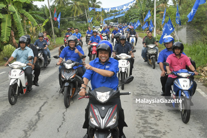 Calon Barisan Nasional Bagan Datuk, Datuk Seri Ahmad Zahid Hamidi (tengah) bersama calon Barisan Nasional Dewan Undangan Negeri Rungkup, Datuk Shahrul Zaman Yahya (dua kiri) meninjau kawasan persekitaran dengan menaiki motosikal sempena kempen Pilihan Raya Umum ke-14 (PRU14) di Sungai Betul, Bagan Datuk, Perak. foto FAREEZ FADZIL, 01 MEI 2018.