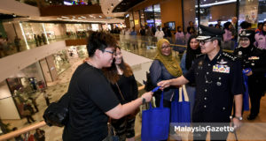 Ketua Polis Kuala Lumpur, Datuk Seri Mazlan Lazim (kanan) memberi penerangan kepada pengunjung sambil mengedarkan risalah pada Program Walkabout Pencegahan Jenayah Polis Kuala Lumpur sempena Pilihan Raya Umum ke-14 (PRU14) di pusat membeli belah MyTown, Kuala Lumpur. foto FAREEZ FADZIL, 06 MEI 2018.