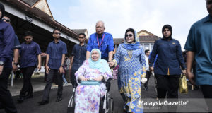 Calon Barisan Nasional P.085 Pekan, Datuk Seri Najib Tun Razak merangkap Pengerusi Barisan Nasional menolak ibunya yang berkerusi roda, Tun Rahah Mohammad Noah sambil diiringi isterinya, Datin Seri Rosmah Mansor selepas membuang undi pada hari pengundian sempena Pilihan Raya Umum ke-14 (PRU14) di Sekolah Sains Sultan Haji Ahmad Shah, Pekan. foto SYAFIQ AMBAK, 09 MEI 2018