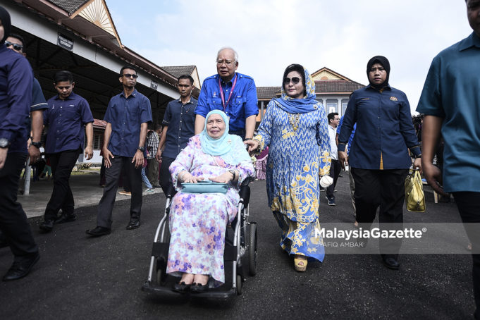 Calon Barisan Nasional P.085 Pekan, Datuk Seri Najib Tun Razak merangkap Pengerusi Barisan Nasional menolak ibunya yang berkerusi roda, Tun Rahah Mohammad Noah sambil diiringi isterinya, Datin Seri Rosmah Mansor selepas membuang undi pada hari pengundian sempena Pilihan Raya Umum ke-14 (PRU14) di Sekolah Sains Sultan Haji Ahmad Shah, Pekan. foto SYAFIQ AMBAK, 09 MEI 2018