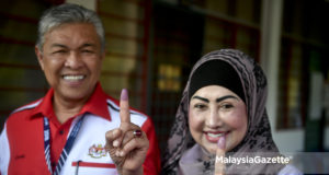 Calon Barisan Nasional P.075 Bagan Datuk, Datuk Seri Ahmad Zahid Hamidi (kiri) ditemani isteri, Datin Seri Hamidah Khamis menunjukkan jari yang berdakwat selepas selesai membuang undi pada hari mengundi sempena Pilihan Raya Umum ke-14 (PRU14) di Madrasah Manbail Ulum Sungai Nipah Darat, Bagan Datuk, Perak. foto FAREEZ FADZIL, 09 MEI 2018