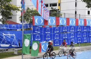 Beberapa budak bermain basikal melintasi bendera-bendera parti politik menjelang Pilihanraya Umum ke-14 (PRU14) ketika tinjauan Lensa Malaysia Gazette di sekitar Pantai Dalam, Bangsar, Kuala Lumpur. foto FAREEZ FADZIL, 22 APRIL 2018