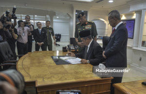 Menteri Pertahanan, Mohamad Sabu menurunkan tandatangan pada nota kerja sebelum memulakan tugas pada hari pertama sebagai Menteri Pertahanan yang baharu di Wisma Pertahanan, Jalan Padang Tembak, Kuala Lumpur. foto AFFAN FAUZI, 22 MEI 2018.