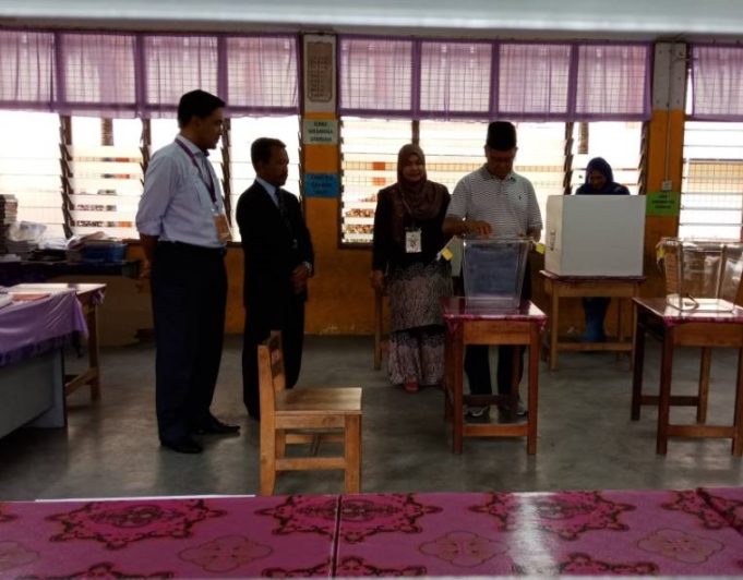 Mustapa memasukkan kertas undi dalam kotak undi yang disediakan di pusat pengundian SK Batu Gajah, Jeli.