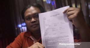 Mohd Fadzley Mohd Yusof, 38 menunjukkan salinan laporan polis yang dibuatnya ketika temubual eksklusif bersama mangsa yang dikatakan dituduh dan difitnah untuk cubaan ugut membunuh Perdana Menteri, Tun Dr. Mahathir Mohamad di Kuala Lumpur. foto NOOR ASREKUZAIREY SALIM, 01 JUN 2018
