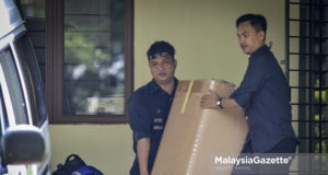 Beberapa anggota polis membawa keluar beberapa kotak dipercaya mengandungi barangan yang ada kaitan dengan siasatan kes membabitkan bekas Perdana Menteri, Datuk Seri Najib Tun Razak di Presint 10, Putrajaya. foto HAZROL ZAINAL, 11 JUN 2018.