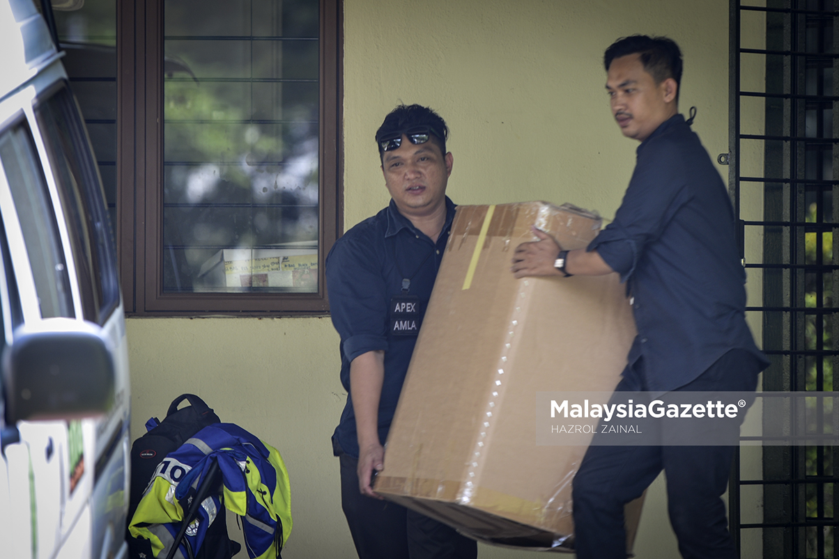 Beberapa anggota polis membawa keluar beberapa kotak dipercaya mengandungi barangan yang ada kaitan dengan siasatan kes membabitkan bekas Perdana Menteri, Datuk Seri Najib Tun Razak di Presint 10, Putrajaya. foto HAZROL ZAINAL, 11 JUN 2018.