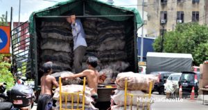 Tiga orang lelaki mengeluarkan beberapa guni beras dari sebuah lori ketika tinjauan lensa MalaysiaGazette di sekitar kawasan Chow Kit, Kuala Lumpur. foto AFFAN FAUZI, 27 SEPTEMBER 2017
