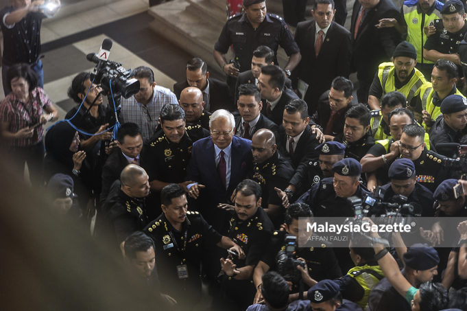 Bekas Perdana Menteri, Datuk Seri Najib Tun Razak sambil diiringi pegawai SPRM dan anggota polis ketika hadir untuk pertuduhan di Mahkamah Sesyen, Kompleks Mahkamah Kuala Lumpur. foto AFFAN FAUZI, 04 JULAI 2018
